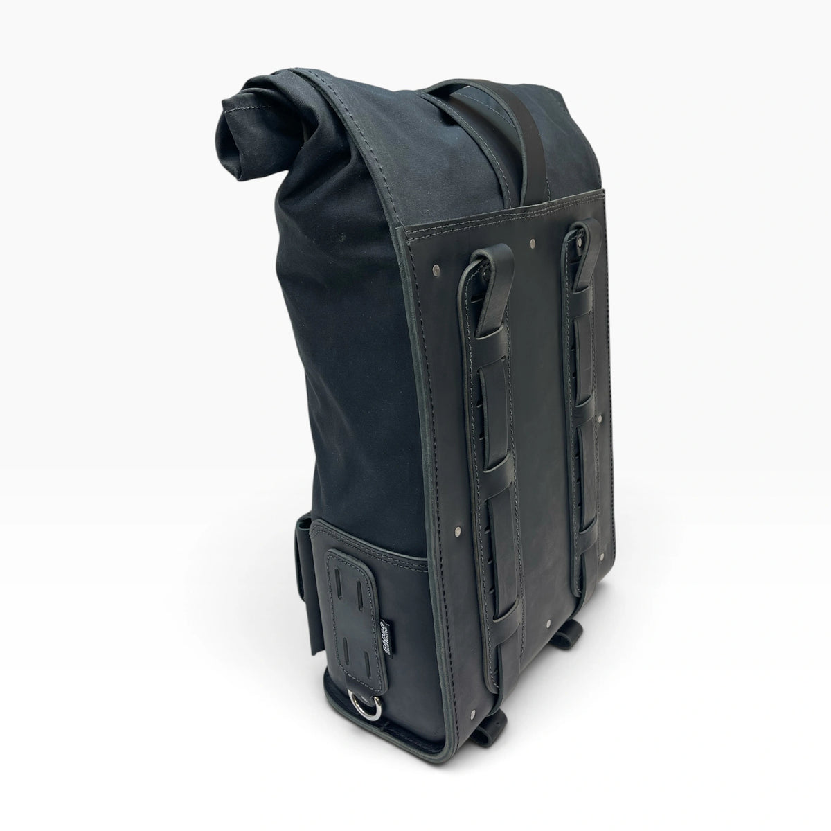 A black roll-top backpack with a weathered, distressed leather look, featuring dual vertical leather straps on the front, a side buckle attachment, and a top carry handle, shown on a white background.